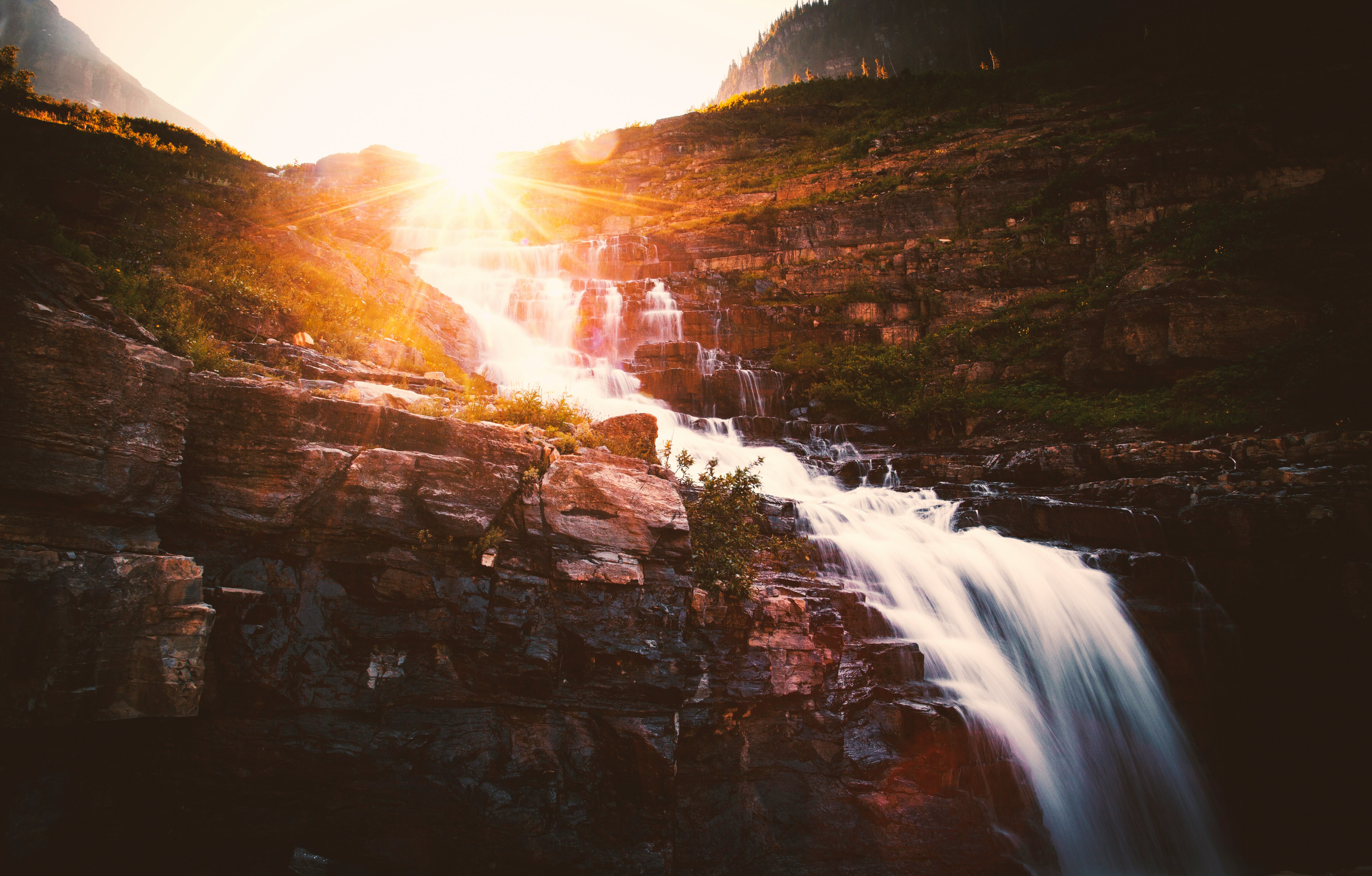 water falls on brown rocky mountain during daytime